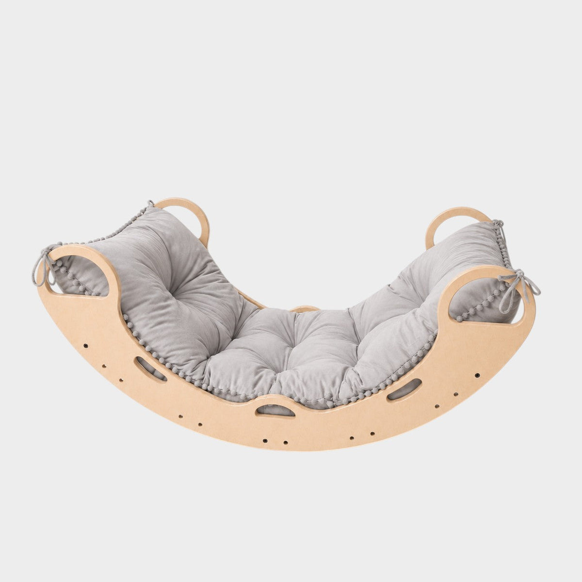 modplay Montessori wooden rocker with a soft grey cushion for climbing, rocking, and resting in a playroom