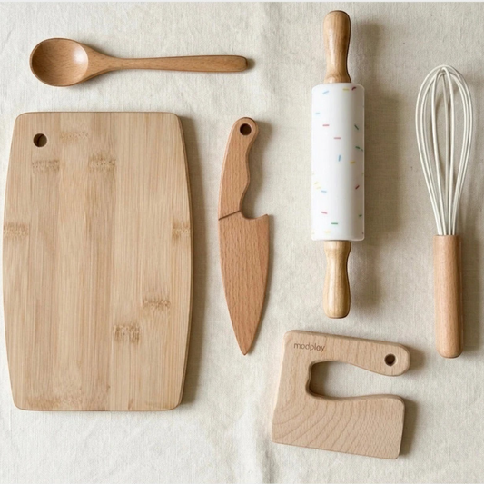modplay wooden Montessori kitchen tool set including a cutting board, safe knife, rolling pin, spoon, and whisk.