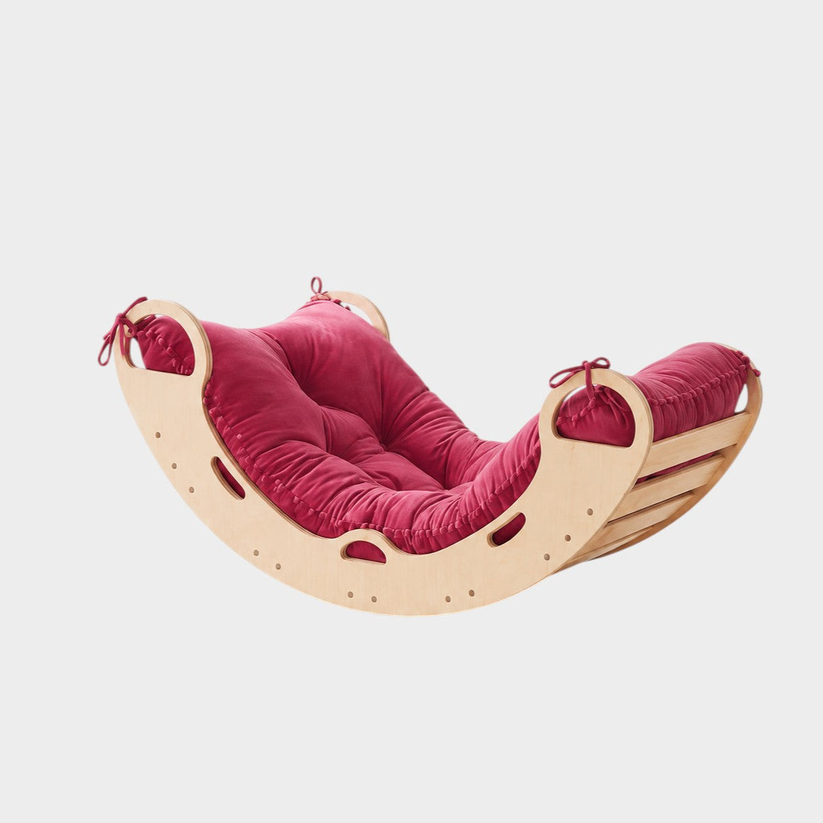 modplay Montessori wooden rocker with a plush red cushion for active play, climbing, and relaxing.